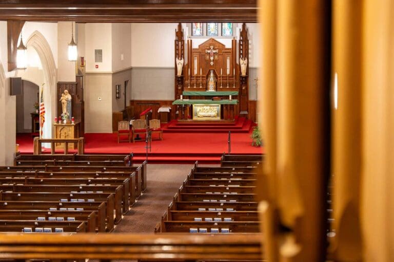 View of a church altar and pews from the organ loft, highlighting a serene worship space.