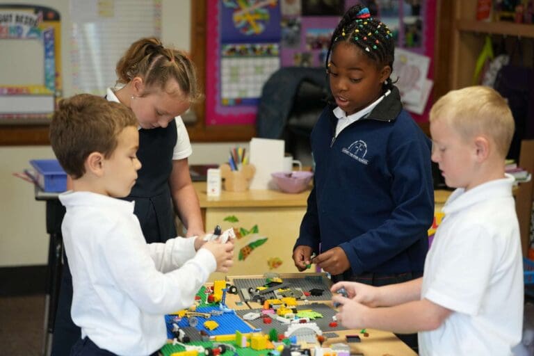 Children collaborating on a LEGO project in a classroom.